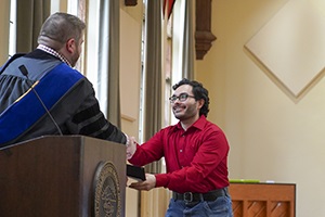 Nick Hausman receives an award from Dr. Nate Beres