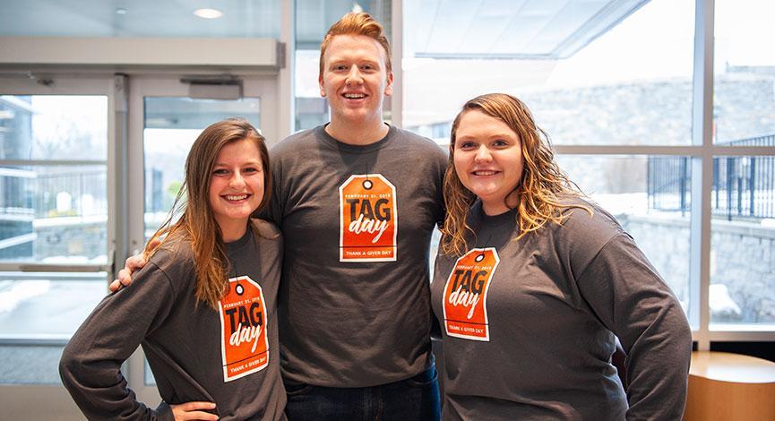 Three students pose with TAG Day shirts