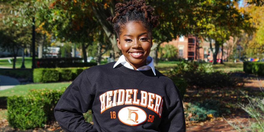 Heidelberg student Ayanna Hayes stands and poses for a picture in a black Heidelberg sweatshirt during a summer day
