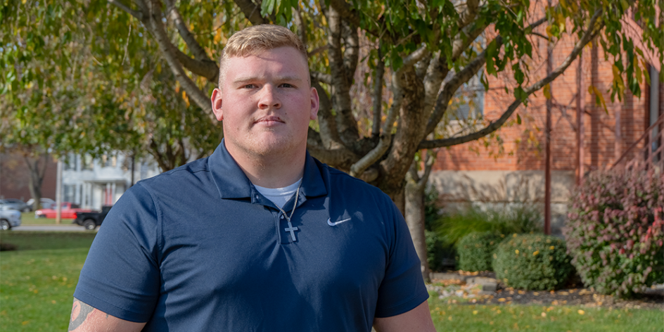 Nik McAvoy standing in front of some trees near University Hall