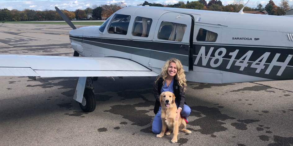 '19 alum Andrea Russell with her Golden Retriever Oliver as they prepare to fly in to Put-In-Bay for a pet emergency.