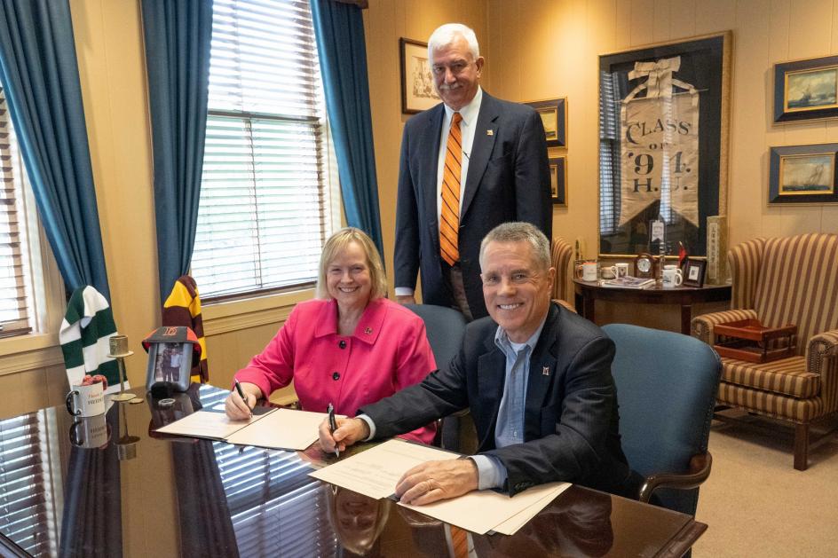 'Berg First Lady Susan McCafferty and President Rob Huntington sign the gift agreement while VP Phil Ness looks on,