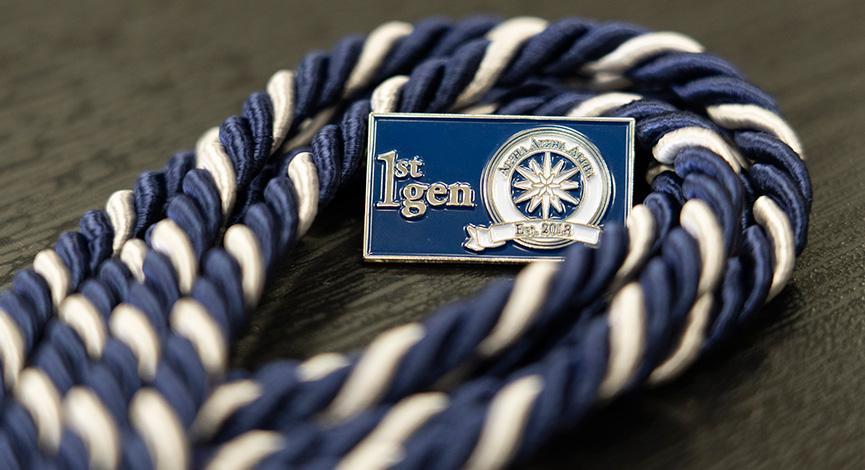 Blue and white cord wrapped three times around a "1st Gen" blue pin with Tri-Alpha logo