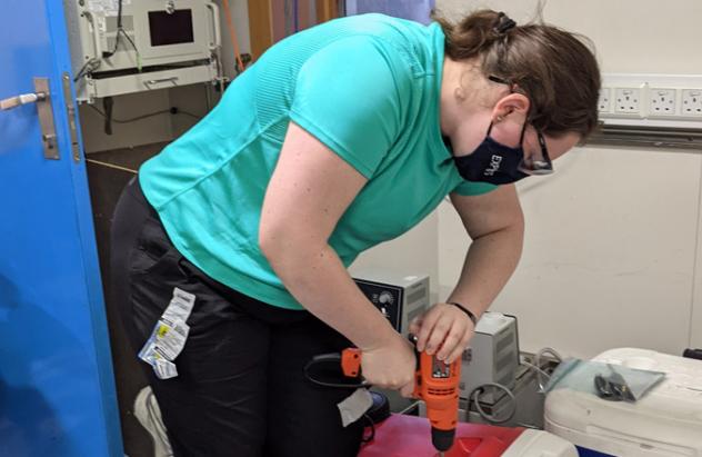 Melanie uses drill on a cooler