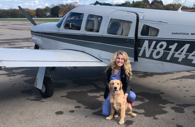 '19 alum Andrea Russell with her Golden Retriever Oliver as they prepare to fly in to Put-In-Bay for a pet emergency.