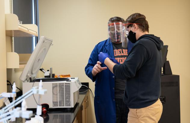 student working with professor in lab