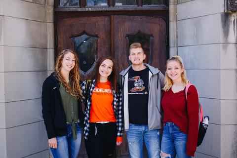 four students posing for a photo, smiling