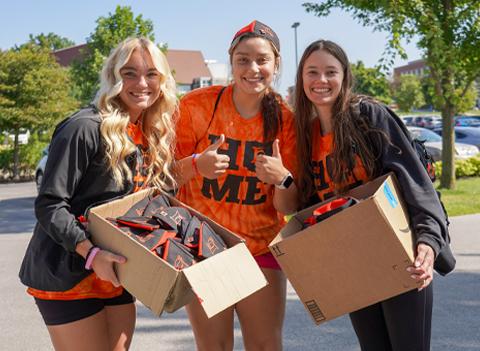 Students holding boxes with Heidelberg Beanies