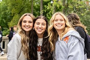 Students smiling in front of T-Bridge